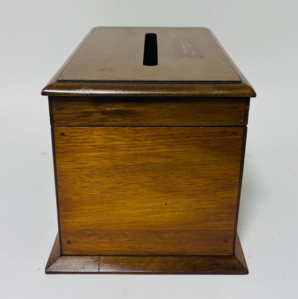 An antique mahogany tabletop letter box featuring a top posting slot, carved LETTERS plaque, key lock mechanism, and bevelled glass front panel. View IX