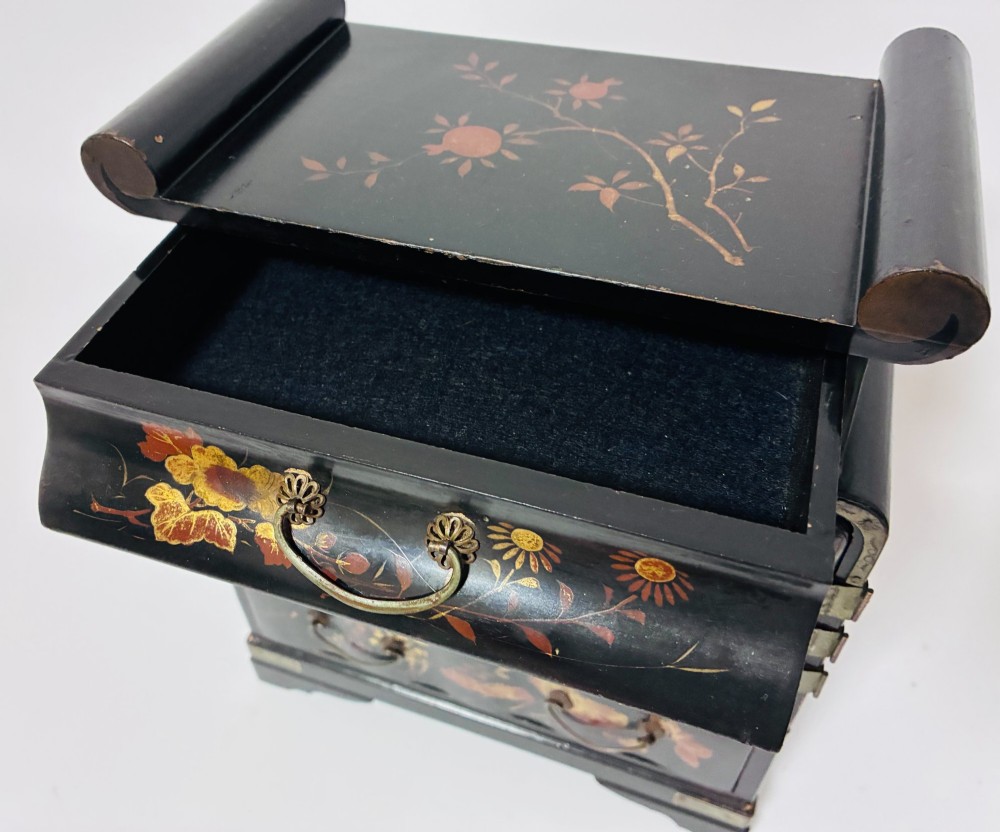 A black lacquered Japanese tabletop cabinet featuring hand-painted botanical motifs and decorative engraved brass corner mounts. View IV