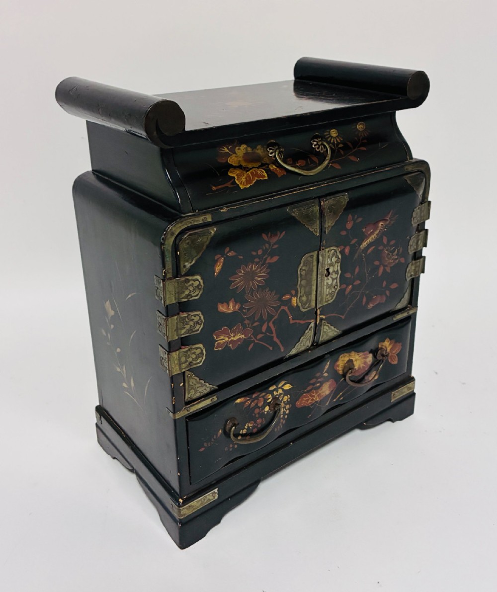 A black lacquered Japanese tabletop cabinet featuring hand-painted botanical motifs and decorative engraved brass corner mounts. View XIII