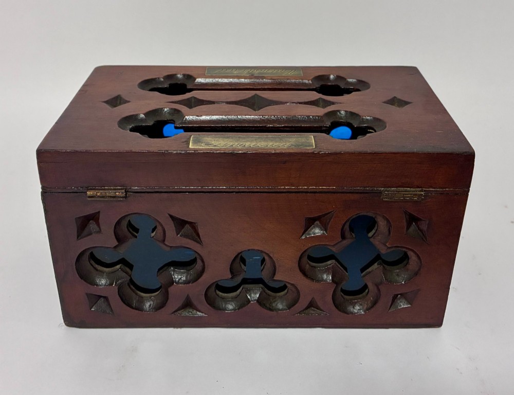 A rectangular dark wood correspondence box with Gothic Revival carved quatrefoil cut-outs backed in blue fabric and brass plates on top marked Answered and Unanswered. View V