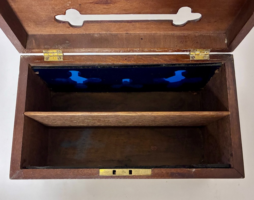 A rectangular dark wood correspondence box with Gothic Revival carved quatrefoil cut-outs backed in blue fabric and brass plates on top marked Answered and Unanswered. View IX