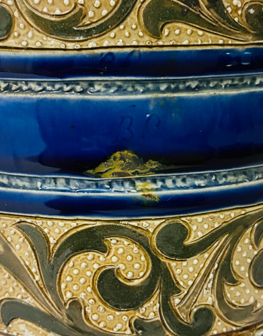 A cylindrical Victorian Doulton Lambeth stoneware biscuit barrel featuring cobalt blue and beige scrollwork decoration, fitted with a silver-plated lid, swing handle, and finial. View XII