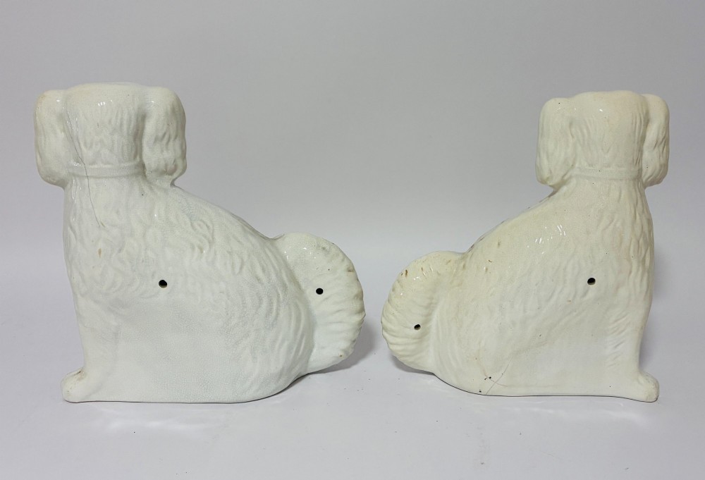A pair of white glazed earthenware Staffordshire dog figures with hand-painted gold details and expressive facial features. View VI