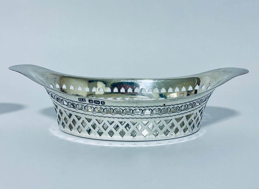 A pair of oval Victorian silver bonbon dishes featuring lattice-pierced reticulated sides and flared handles. View II