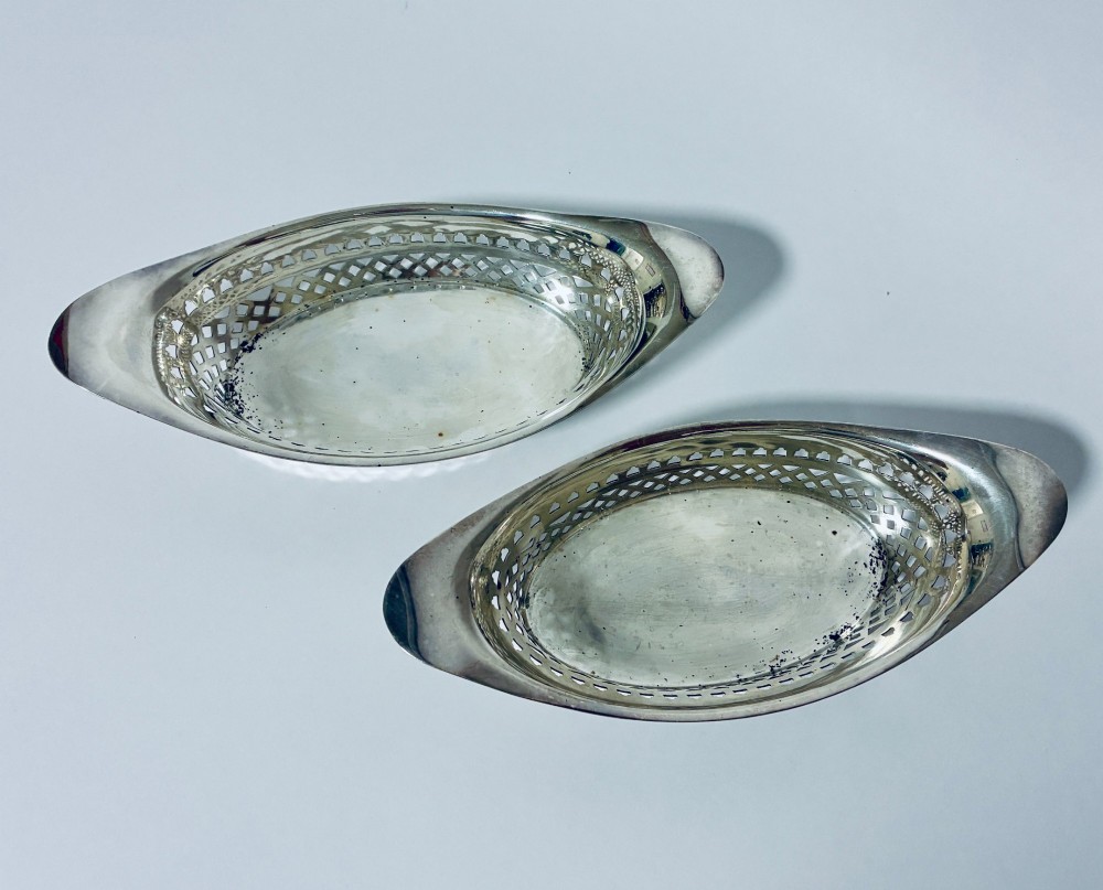 A pair of oval Victorian silver bonbon dishes featuring lattice-pierced reticulated sides and flared handles. View V
