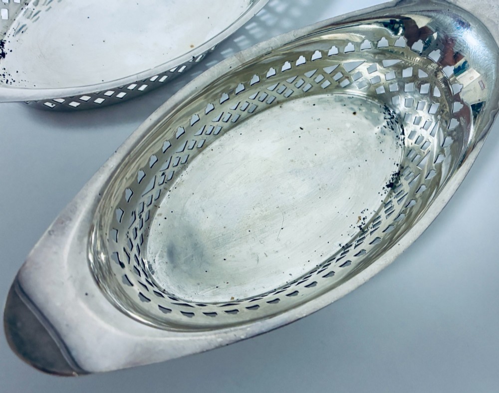 A pair of oval Victorian silver bonbon dishes featuring lattice-pierced reticulated sides and flared handles. View VII