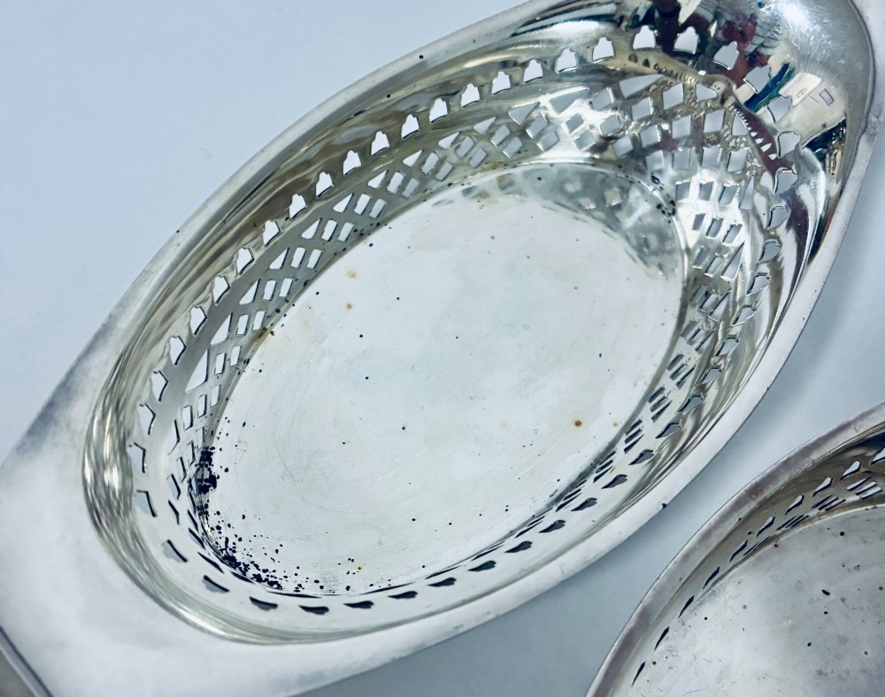 A pair of oval Victorian silver bonbon dishes featuring lattice-pierced reticulated sides and flared handles. View VIII