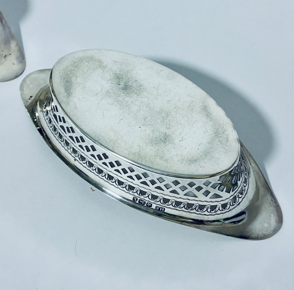 A pair of oval Victorian silver bonbon dishes featuring lattice-pierced reticulated sides and flared handles. View X