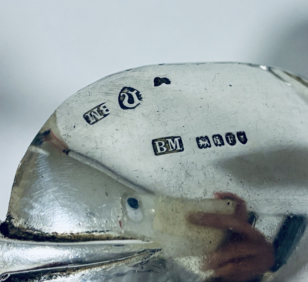 A pair of antique silver spoons featuring oval bowls, decorative spiral stems, and detailed sailing ship finials displayed against a plain background. View VIII