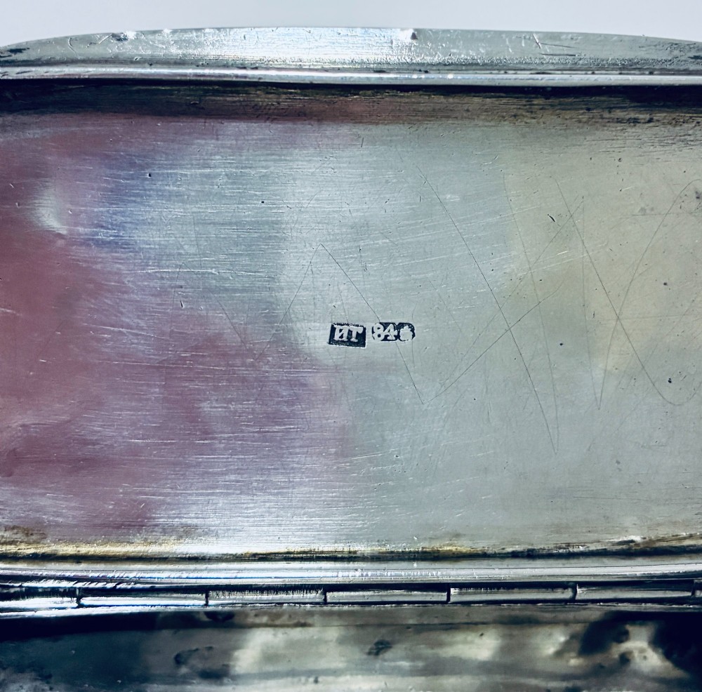 A small, rectangular silver snuff box with rounded corners featuring intricate hand-engraved scrollwork patterns and a central oval cartouche. View IV