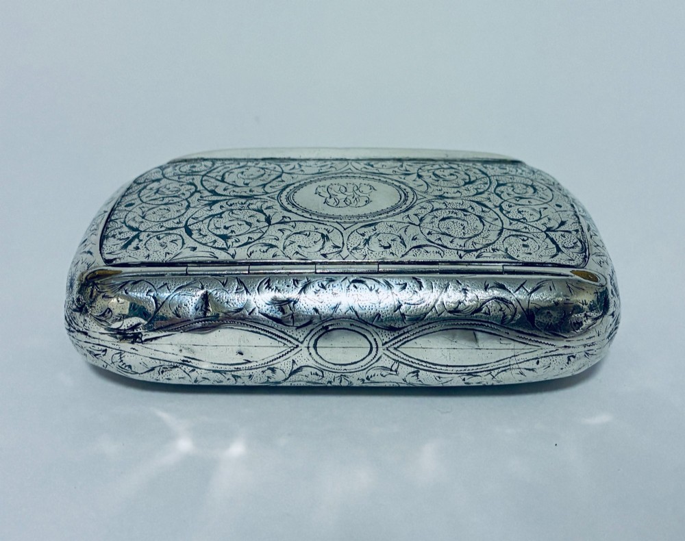 A small, rectangular silver snuff box with rounded corners featuring intricate hand-engraved scrollwork patterns and a central oval cartouche. View VIII