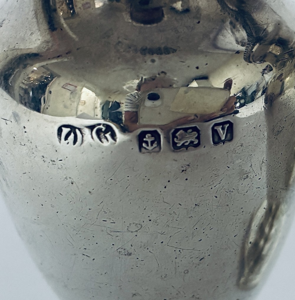 A pair of hallmarked sterling silver baluster pepper pots featuring pierced domed lids with finials and octagonal pedestal bases. View III