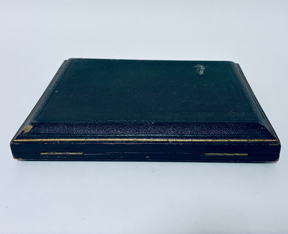 An open dark fitted presentation case lined with white satin and blue velvet containing six silver apostle teaspoons with twisted stems and matching silver sugar tongs. View XII