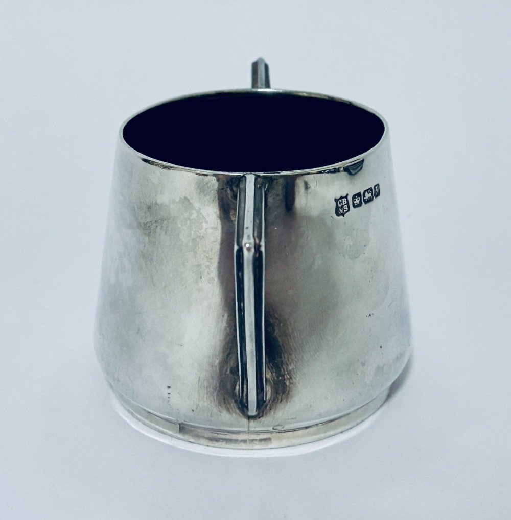 A polished sterling silver Art Deco sugar bowl with sharp triangular side handles and visible hallmarks stamped on the exterior wall. View III