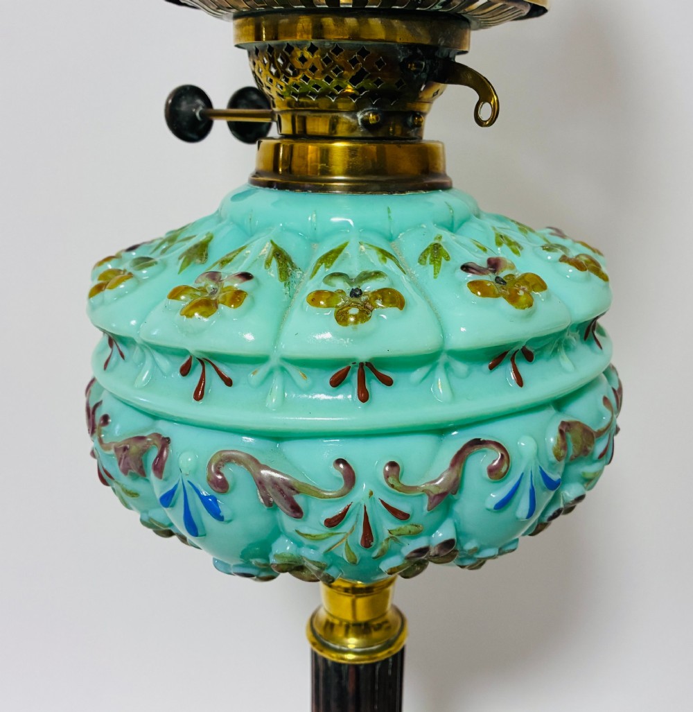 A Victorian oil lamp featuring an etched frosted glass shade, a turquoise enamelled font, and a brass column on a dark stepped base. View II