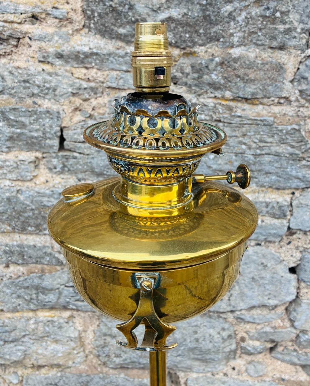 A Victorian brass telescopic floor lamp featuring a ornate tripod base, adjustable vertical stem, and converted oil font fitted with an electrical lamp holder. View II