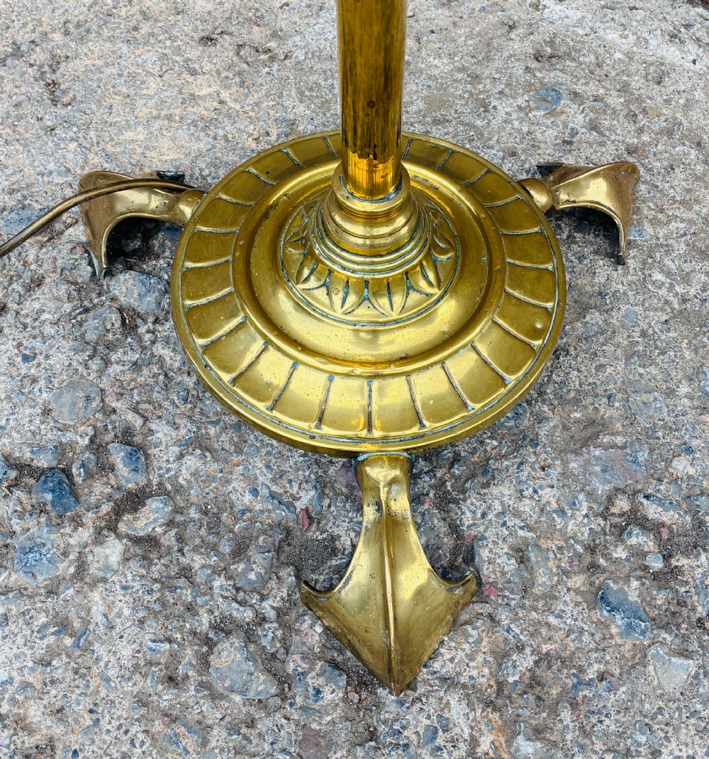 A Victorian brass telescopic floor lamp featuring a ornate tripod base, adjustable vertical stem, and converted oil font fitted with an electrical lamp holder. View VI