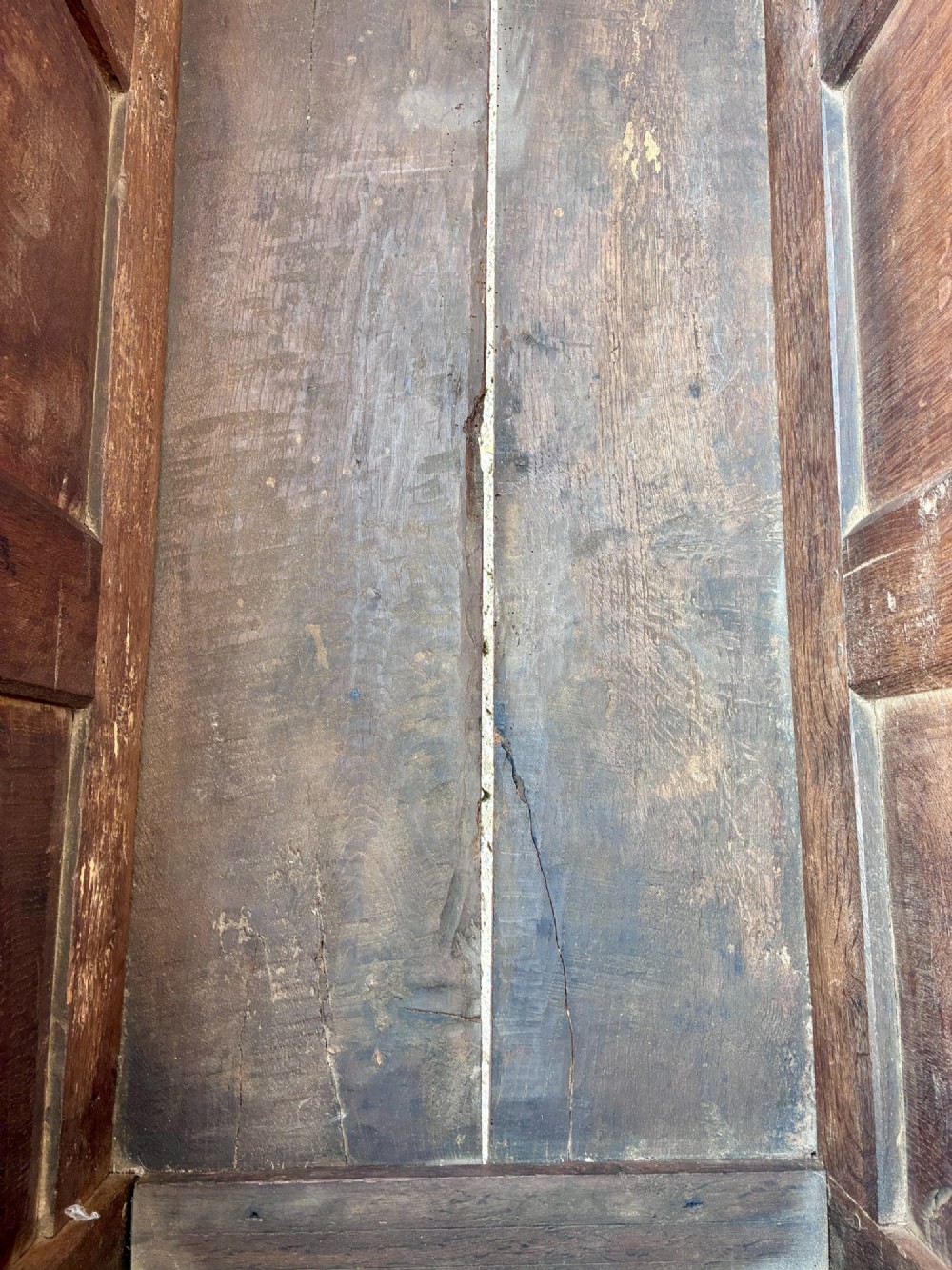 A dark oak 17th century coffer featuring a three-panel carved front with geometric scrollwork and a hinged rectangular lid. View XI