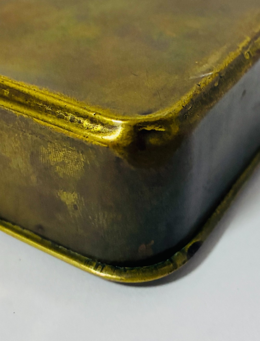 An embossed rectangular brass Princess Mary Christmas tin alongside its original cream greeting card printed with a red royal monogram. View X