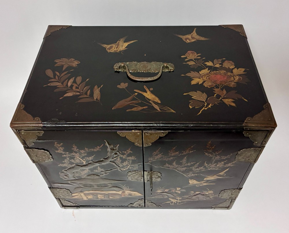 An antique Japanese black lacquer table cabinet decorated with gold bird and landscape scenes, fitted with metal corner brackets and a top handle. View II