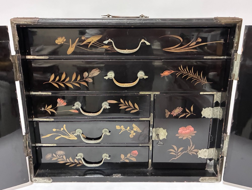 An antique Japanese black lacquer table cabinet decorated with gold bird and landscape scenes, fitted with metal corner brackets and a top handle. View V