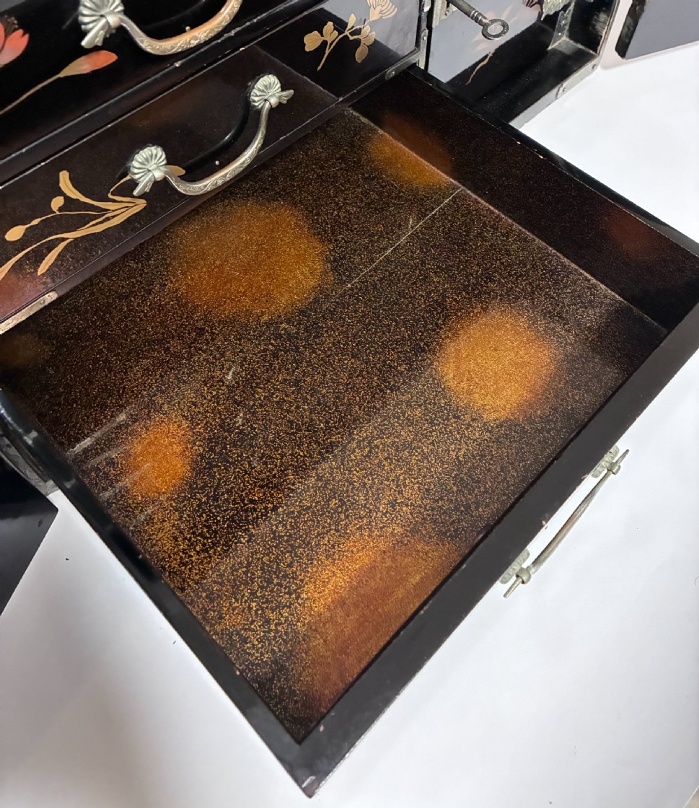 An antique Japanese black lacquer table cabinet decorated with gold bird and landscape scenes, fitted with metal corner brackets and a top handle. View VI