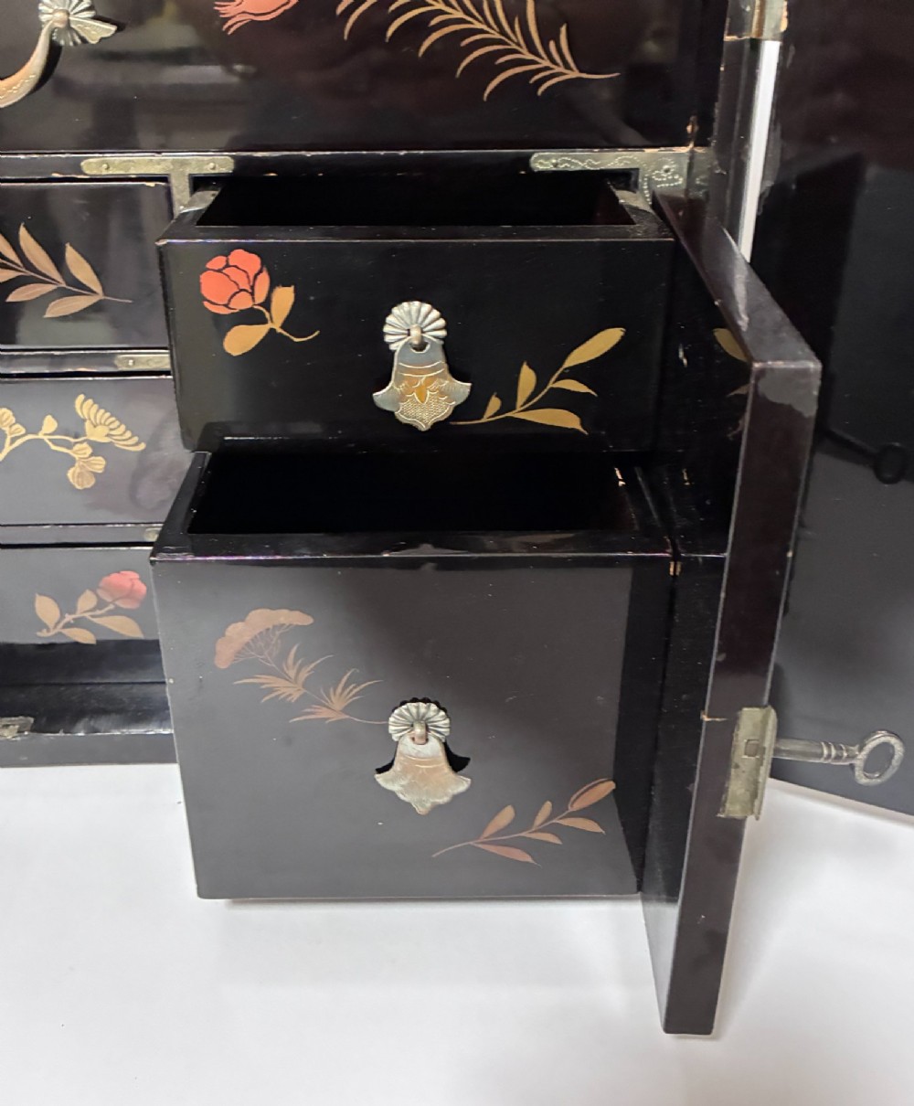 An antique Japanese black lacquer table cabinet decorated with gold bird and landscape scenes, fitted with metal corner brackets and a top handle. View VIII