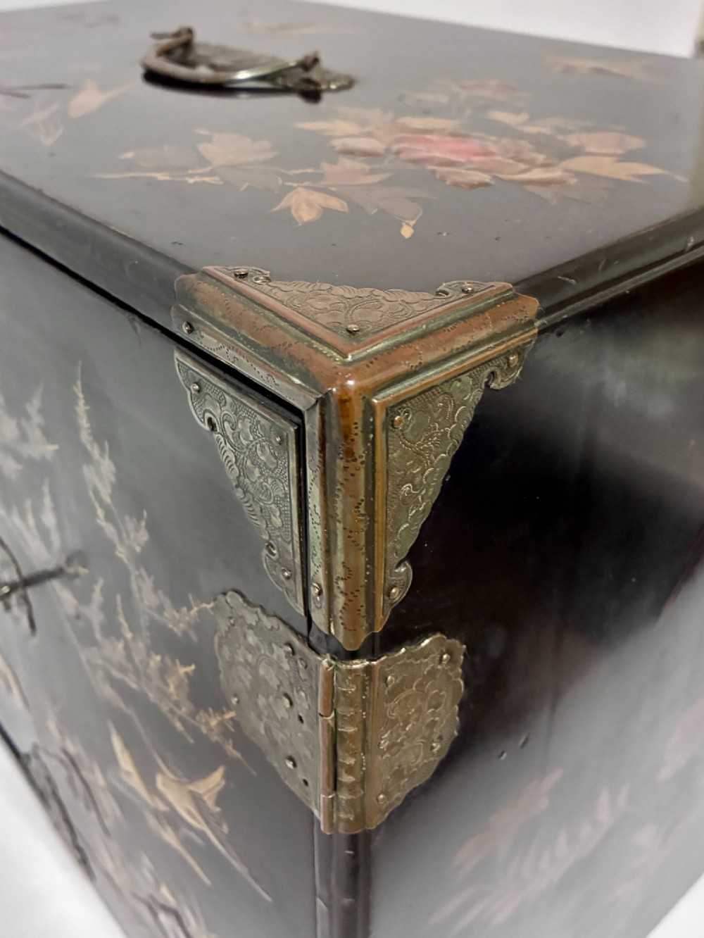 An antique Japanese black lacquer table cabinet decorated with gold bird and landscape scenes, fitted with metal corner brackets and a top handle. View X