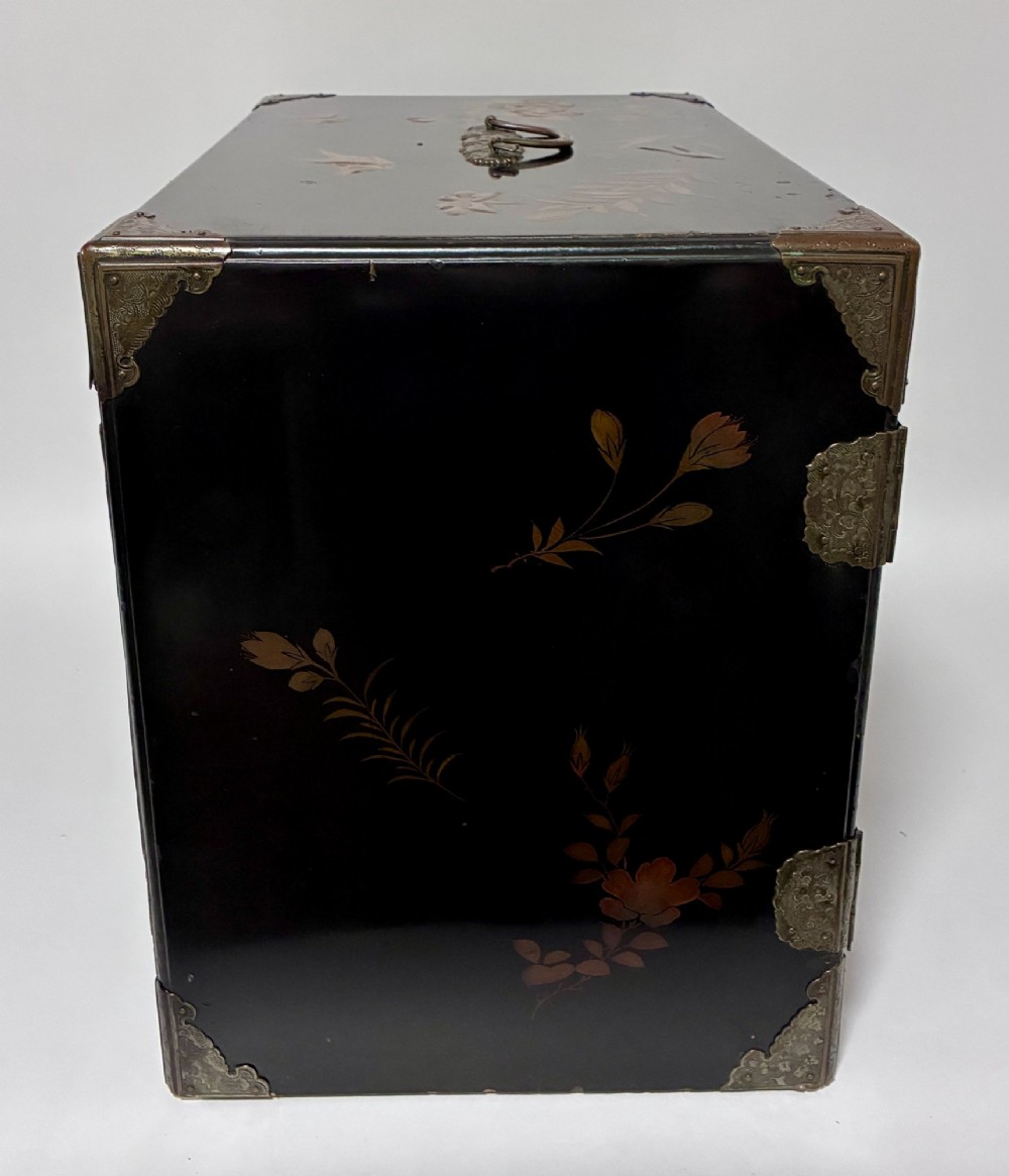 An antique Japanese black lacquer table cabinet decorated with gold bird and landscape scenes, fitted with metal corner brackets and a top handle. View XIV