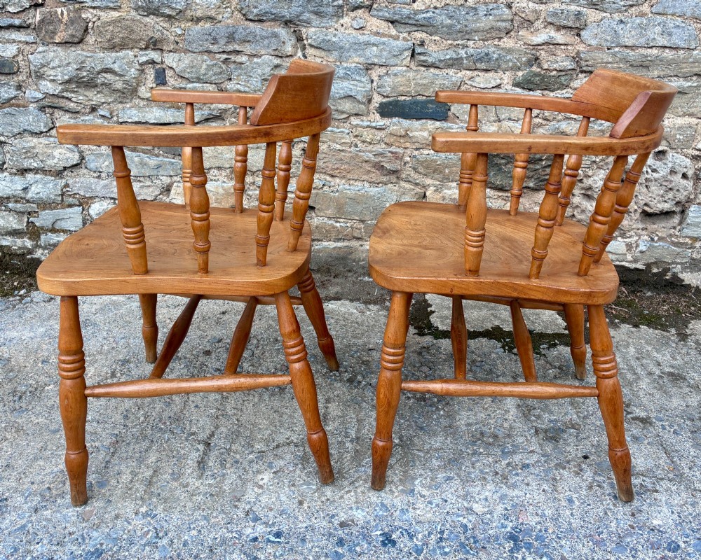 A pair of antique wooden captains chairs with contoured elm seats, turned spindles, rounded armrests, and turned legs. View III