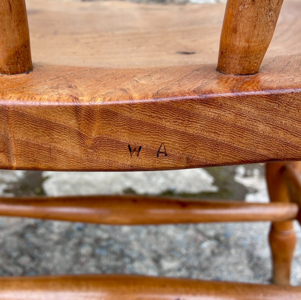 A pair of antique wooden captains chairs with contoured elm seats, turned spindles, rounded armrests, and turned legs. View V