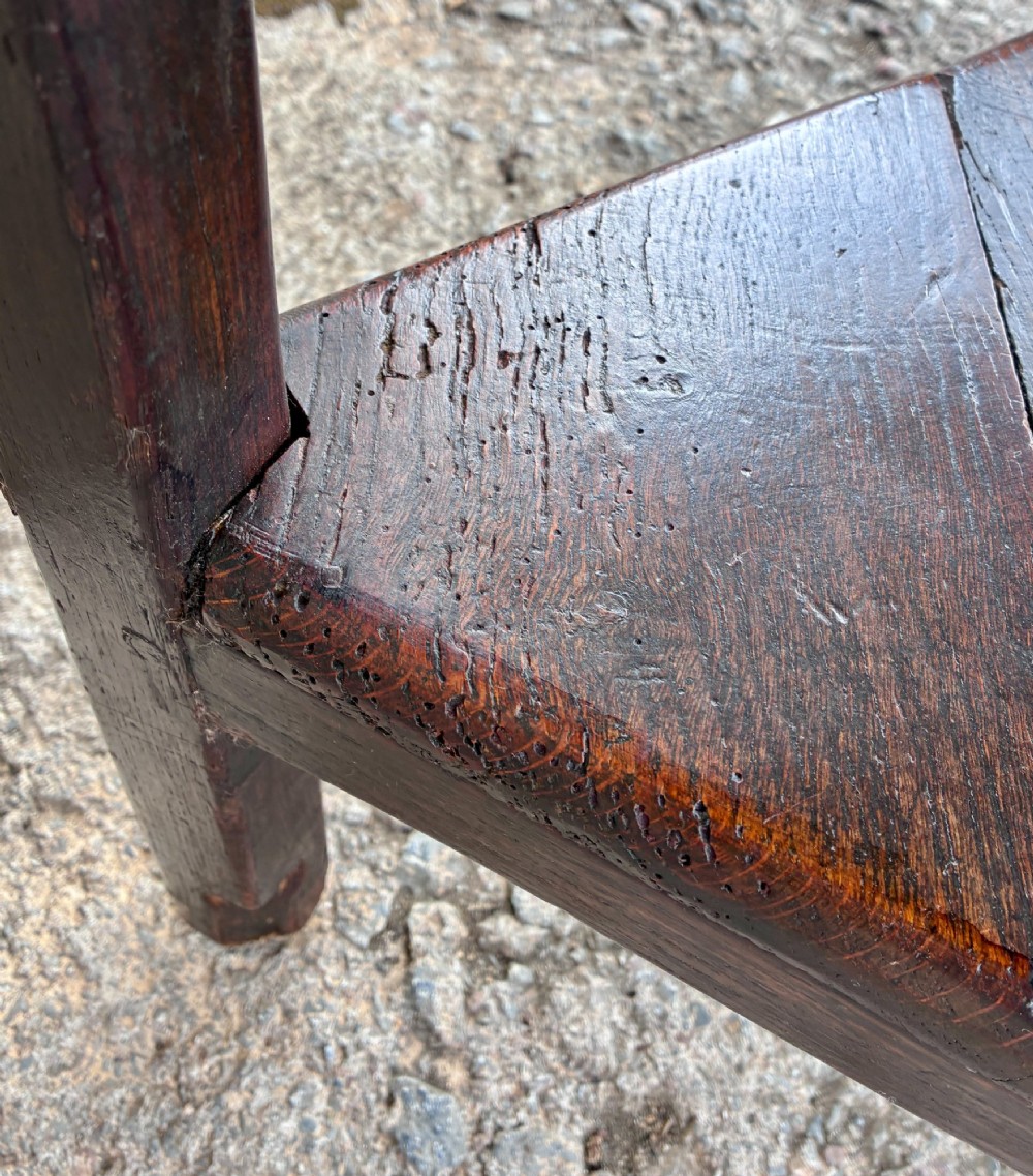 An antique Georgian dark oak cricket table featuring a circular planked top resting on three straight legs with a lower triangular shelf. View XIII