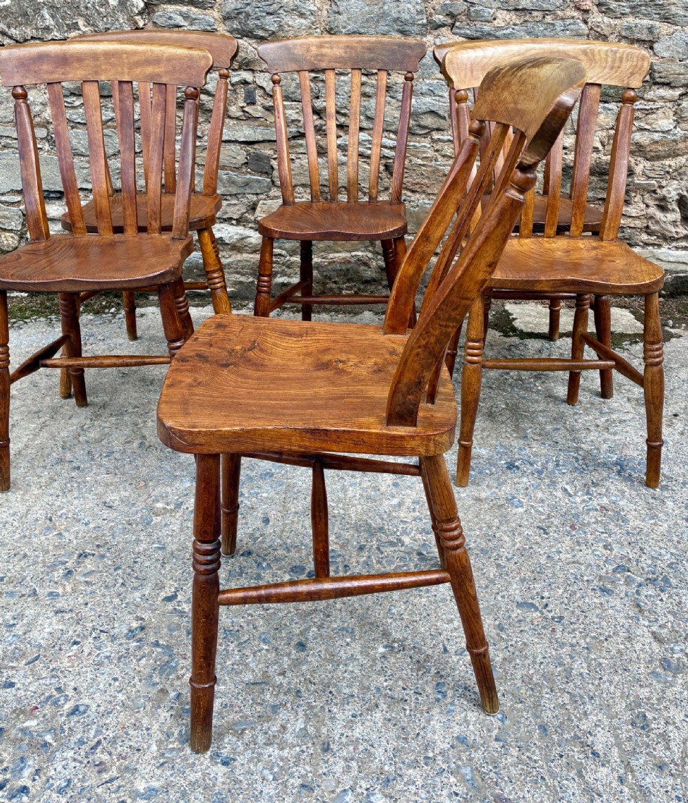 A set of six Victorian country dining chairs featuring curved top rails, vertical lathe back slats, shaped solid elm seats, and turned legs. View VII
