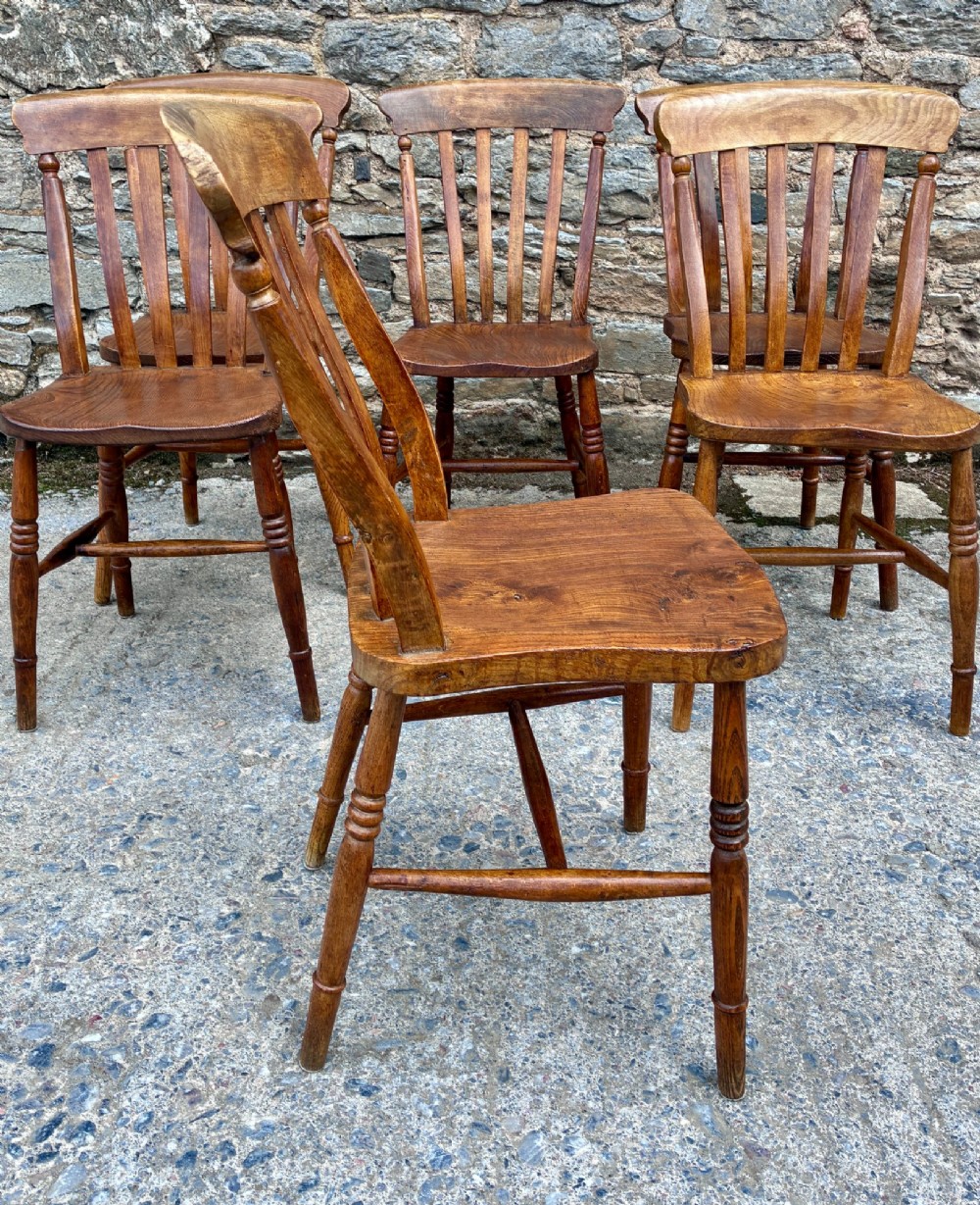 A set of six Victorian country dining chairs featuring curved top rails, vertical lathe back slats, shaped solid elm seats, and turned legs. View VIII