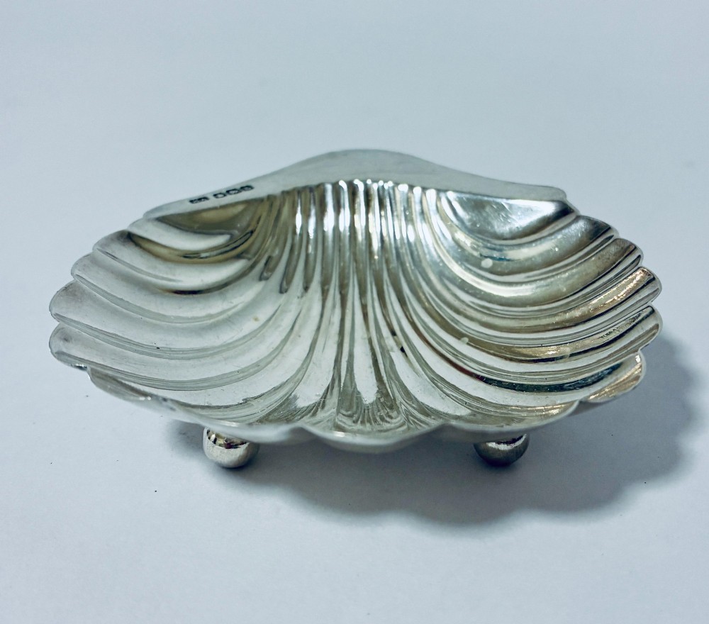 A sterling silver shell-shaped butter dish featuring fluted grooves and visible maker hallmarks on the top rim. View III