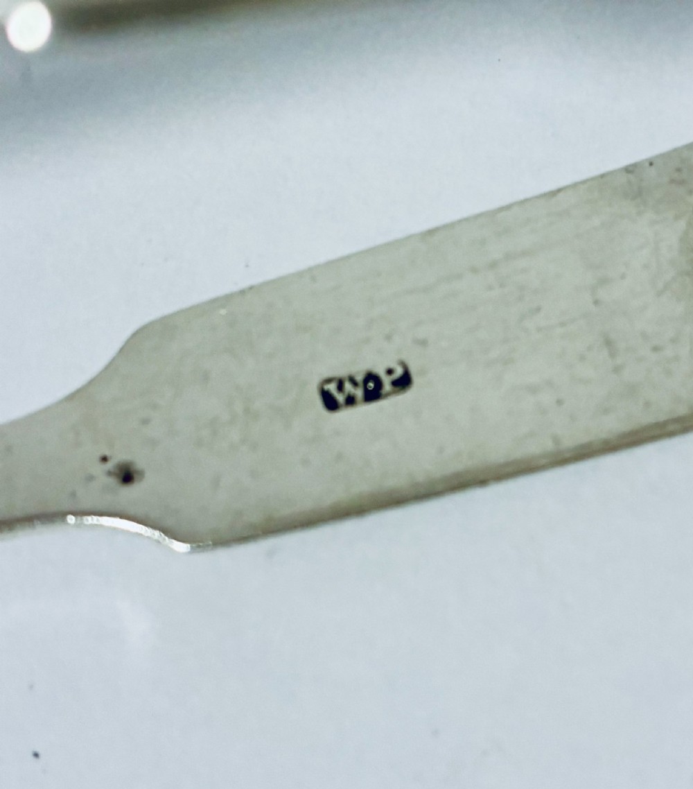 A pair of plain polished sterling silver sugar tongs with spoon-shaped grips and assay hallmarks stamped along the inner curve. View V