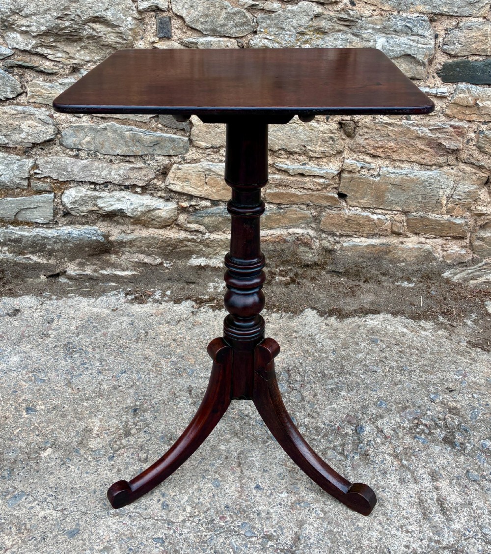 A Regency era dark mahogany tilt-top wine table featuring a rectangular surface, turned central pedestal stem, and a splayed tripod base. View V