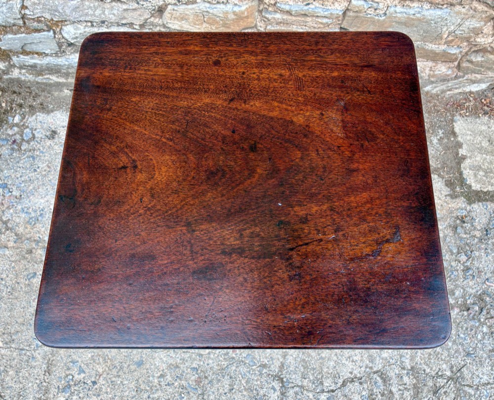 A Regency era dark mahogany tilt-top wine table featuring a rectangular surface, turned central pedestal stem, and a splayed tripod base. View VI