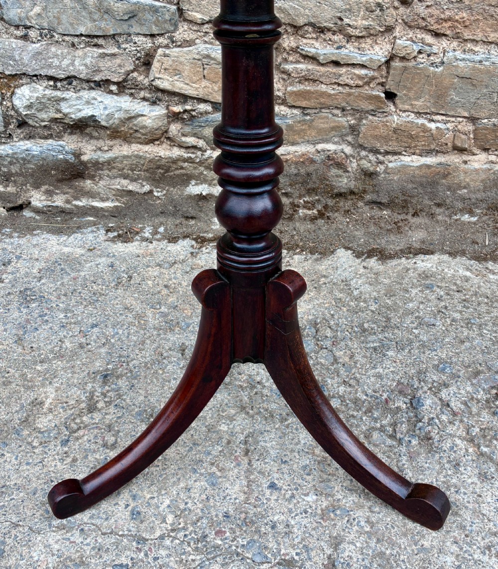 A Regency era dark mahogany tilt-top wine table featuring a rectangular surface, turned central pedestal stem, and a splayed tripod base. View VII