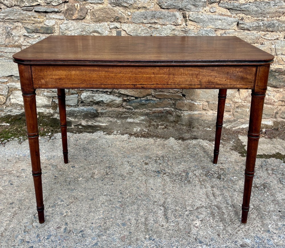 A rectangular Georgian mahogany side table featuring rounded top corners and four ring-turned tapered legs. View II