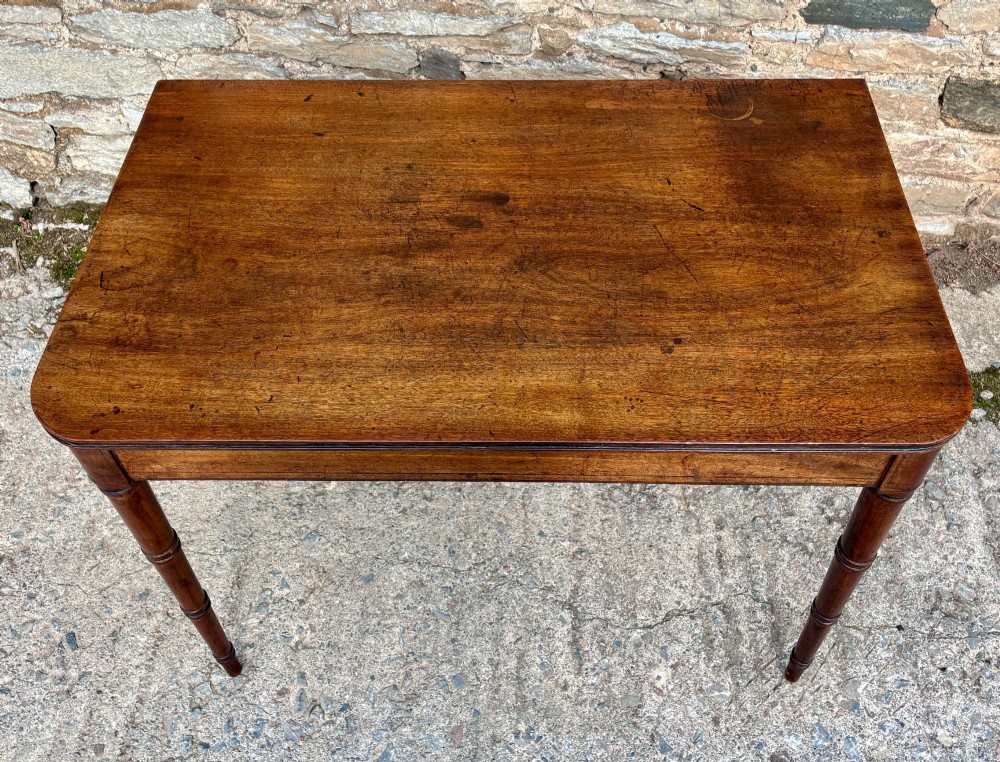 A rectangular Georgian mahogany side table featuring rounded top corners and four ring-turned tapered legs. View III