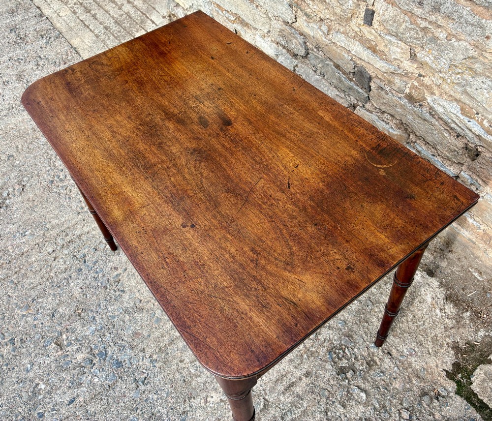 A rectangular Georgian mahogany side table featuring rounded top corners and four ring-turned tapered legs. View VI
