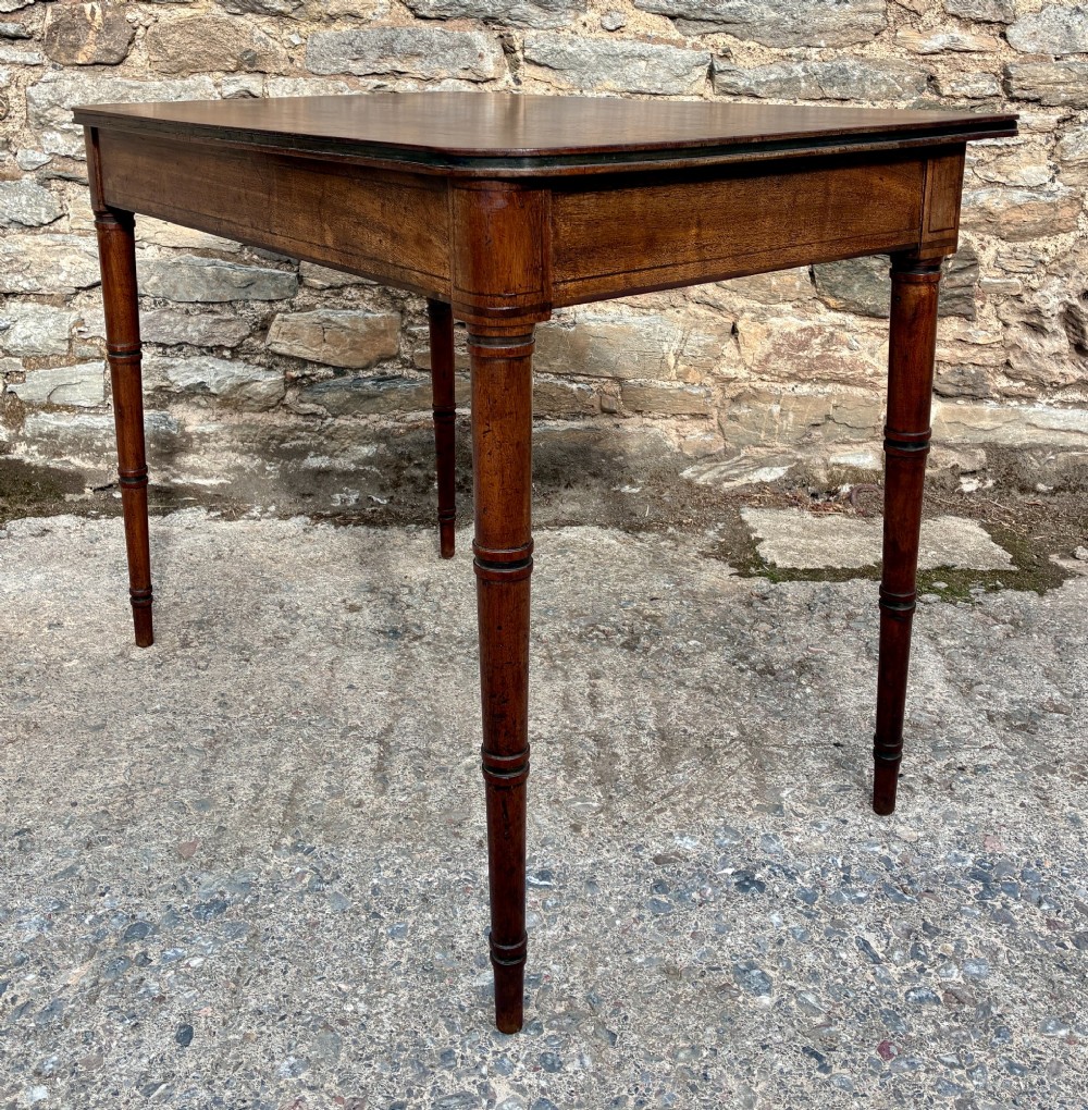 A rectangular Georgian mahogany side table featuring rounded top corners and four ring-turned tapered legs. View VII