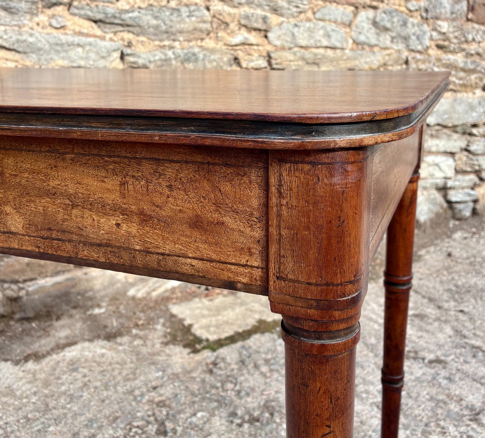 A rectangular Georgian mahogany side table featuring rounded top corners and four ring-turned tapered legs. View VIII