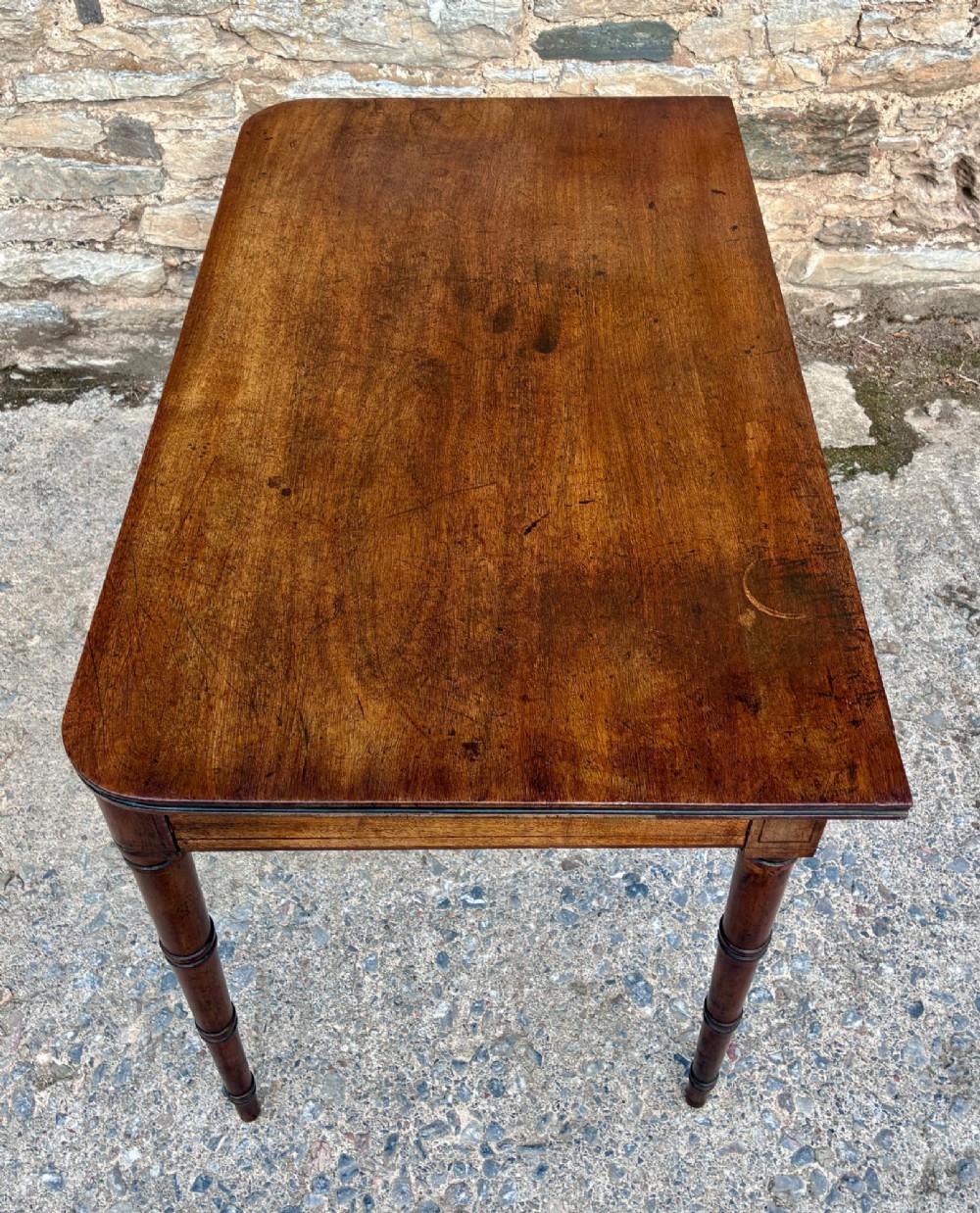 A rectangular Georgian mahogany side table featuring rounded top corners and four ring-turned tapered legs. View IX