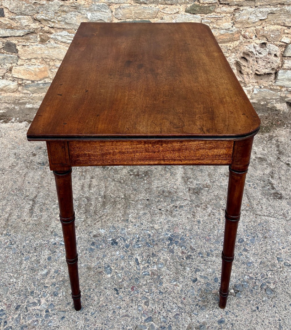 A rectangular Georgian mahogany side table featuring rounded top corners and four ring-turned tapered legs. View XII