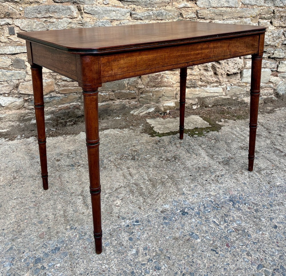 A rectangular Georgian mahogany side table featuring rounded top corners and four ring-turned tapered legs. View XIII