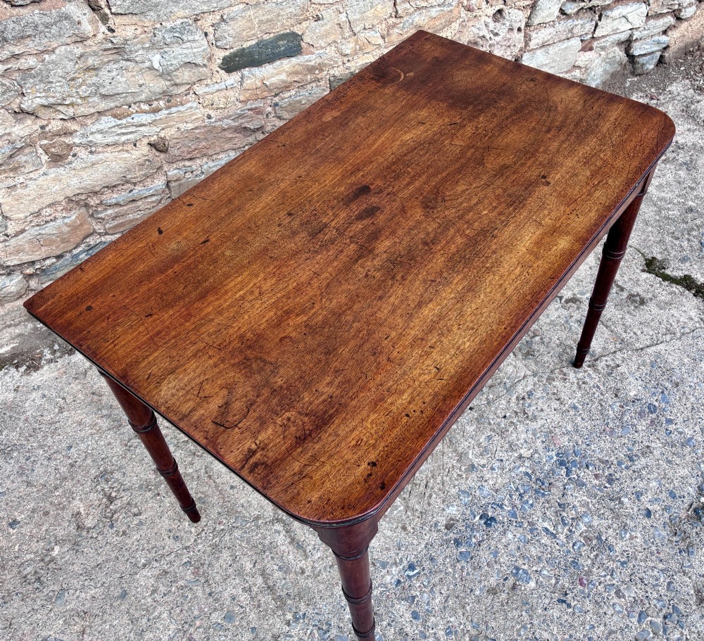 A rectangular Georgian mahogany side table featuring rounded top corners and four ring-turned tapered legs. View XIV