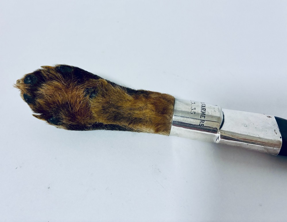 An antique page turner featuring a dark ebony blade connected via a silver collar to an otter paw handle. View VII