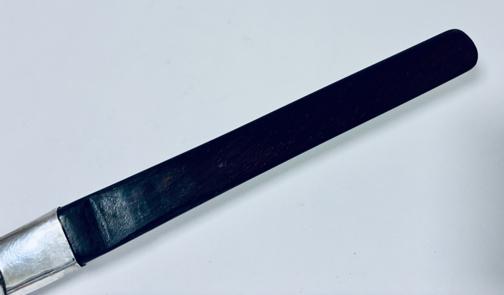An antique page turner featuring a dark ebony blade connected via a silver collar to an otter paw handle. View X